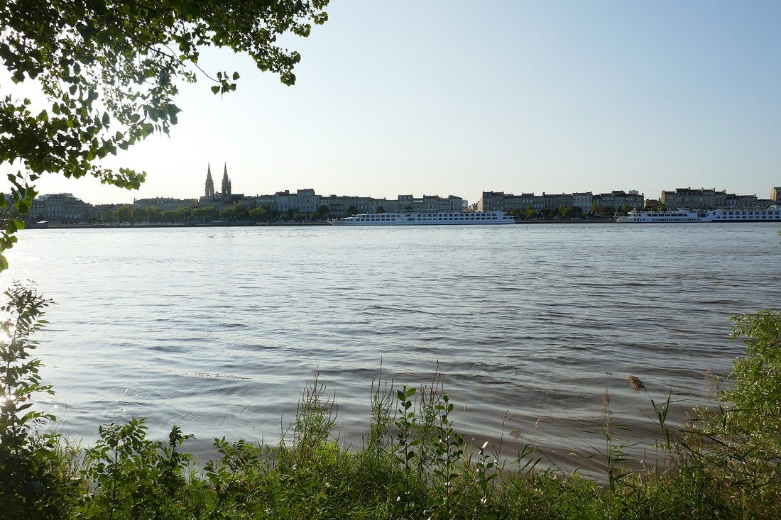 La Garonne et la rive gauche de Bordeaux vues depuis la berge de Darwin, avec des clochers à l'horizon