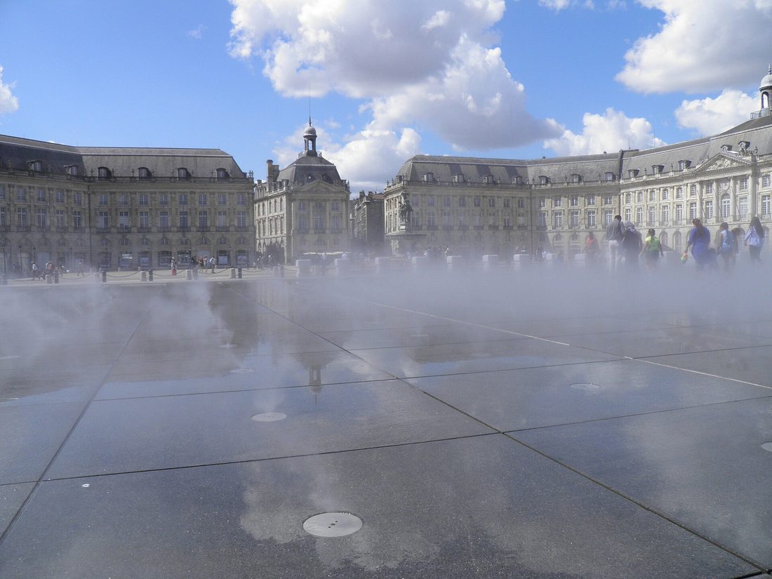 L'effet brouillard du miroir d'eau devant la place de la Bourse, avec des promeneurs