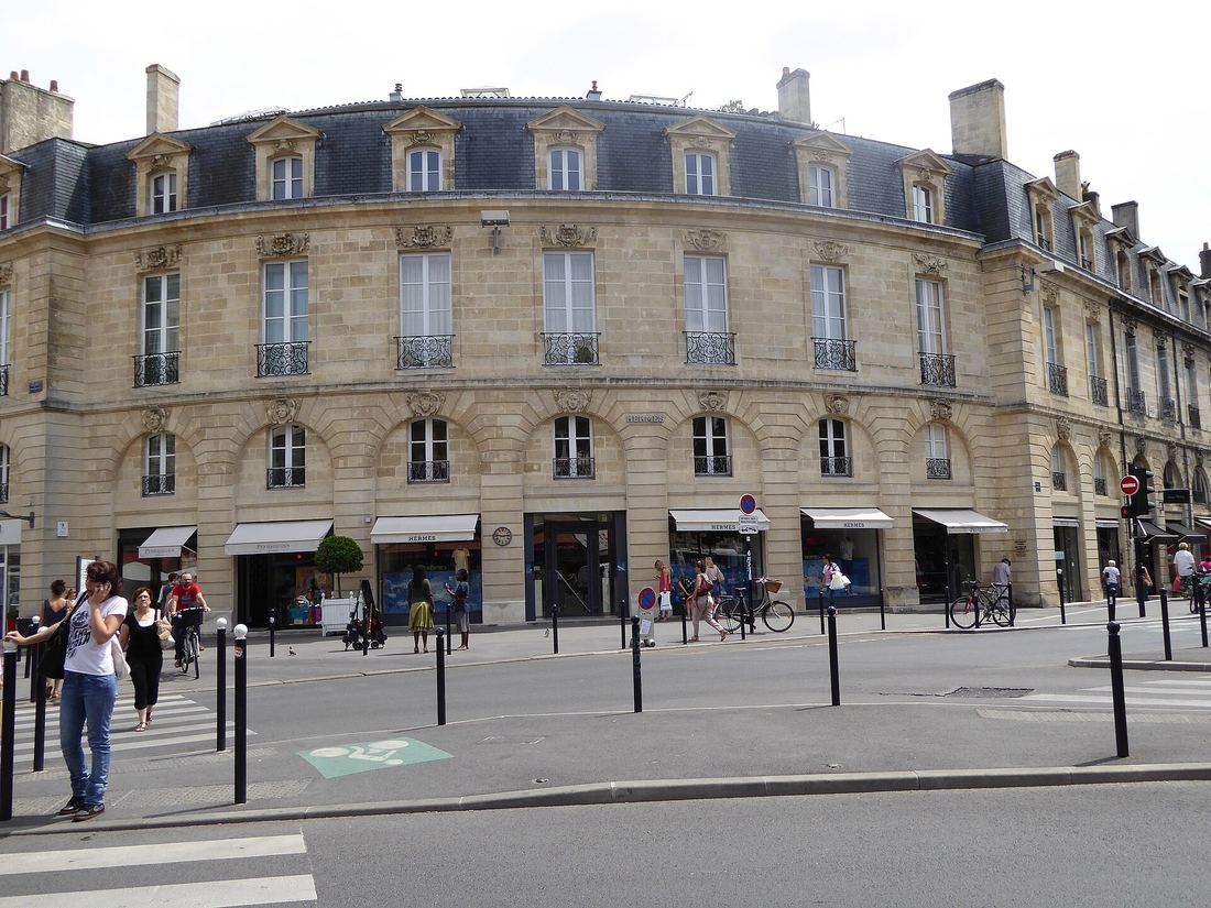 Les façades en pierre et en arc de cercle de la place Gambetta, avec leurs toits en ardoise et leurs boutiques